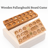Wooden Pallanghuzhi board game with compartments on a white background